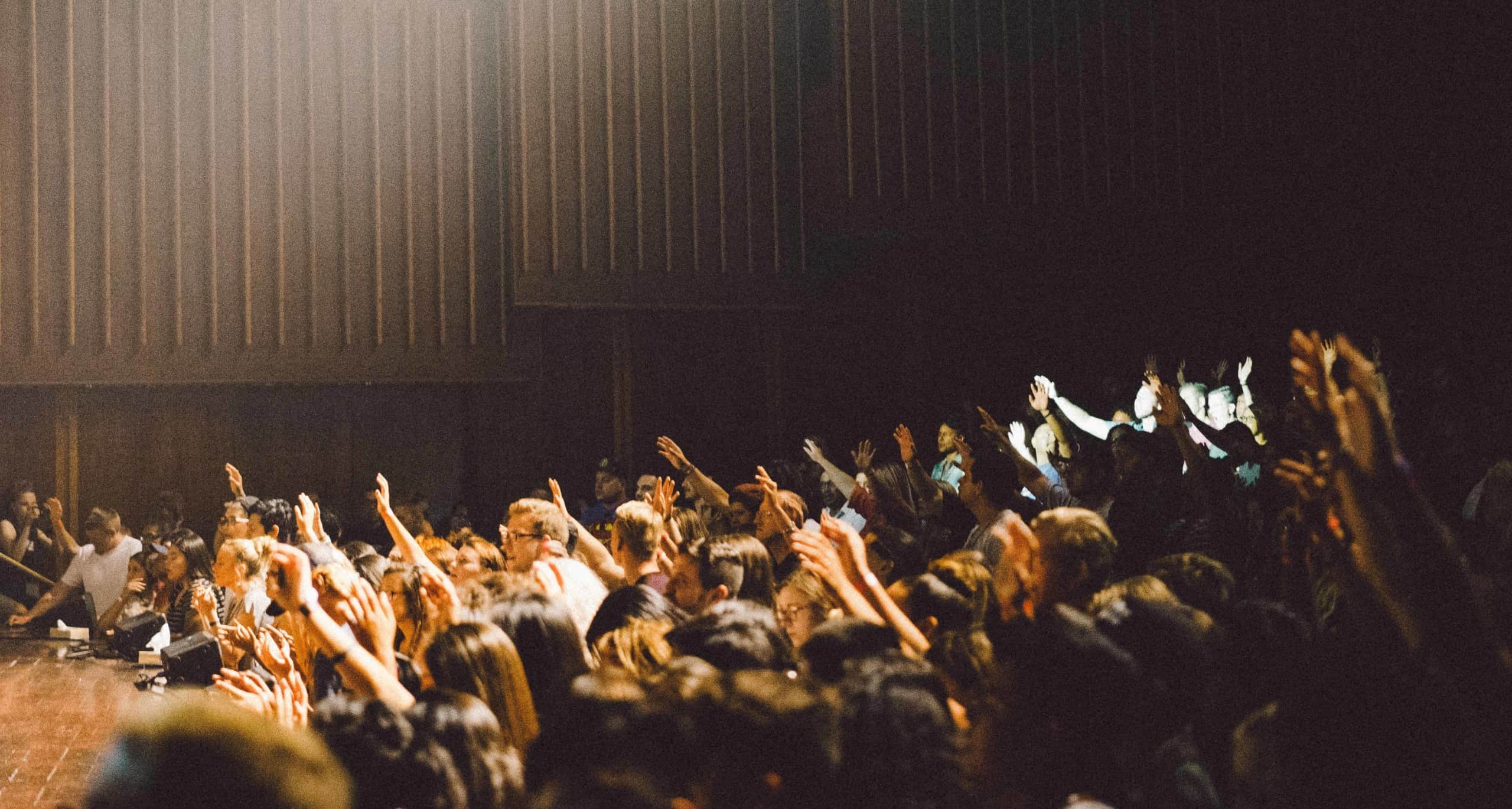Personas levantando las manos en una conferencia - by Edwin Andrade